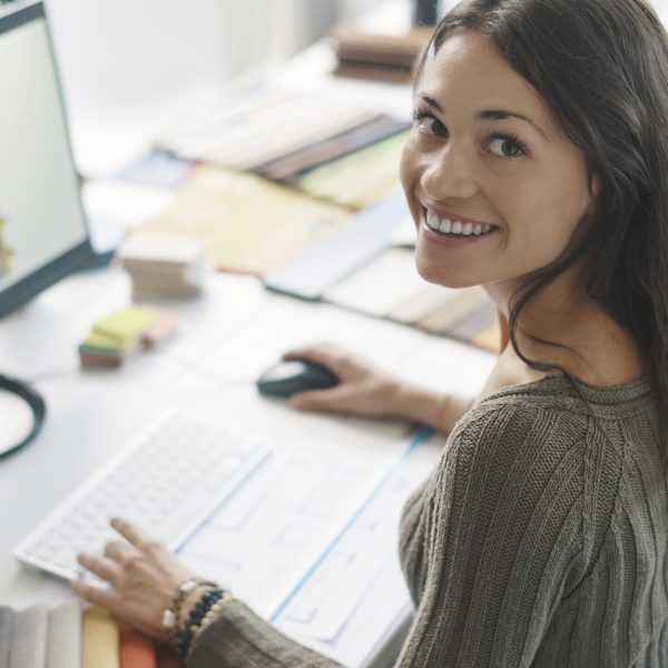 female architect by her computer but looking at the camera